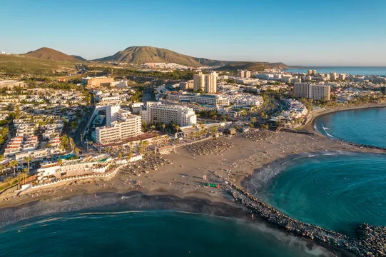 Beach promenade with sun loungers and palm trees in Playa de las Américas, Tenerife